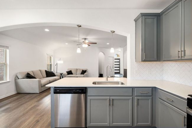 Kitchen with arched walkways, gray cabinets, dishwasher, and recessed lighting | Image 16