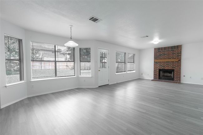 View of breakfast area at bay window and den with fireplace | Image 8