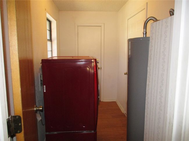 Hallway featuring a textured ceiling, water heater, and wood finished floors | Image 17