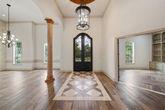 Entrance foyer with a high ceiling, an inviting chandelier, and french doors | Image 4