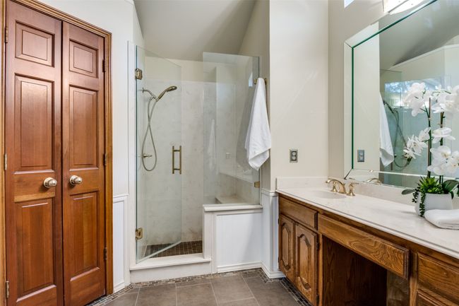 Bathroom featuring a marble finish shower, vanity, a closet, and tile patterned floors | Image 23