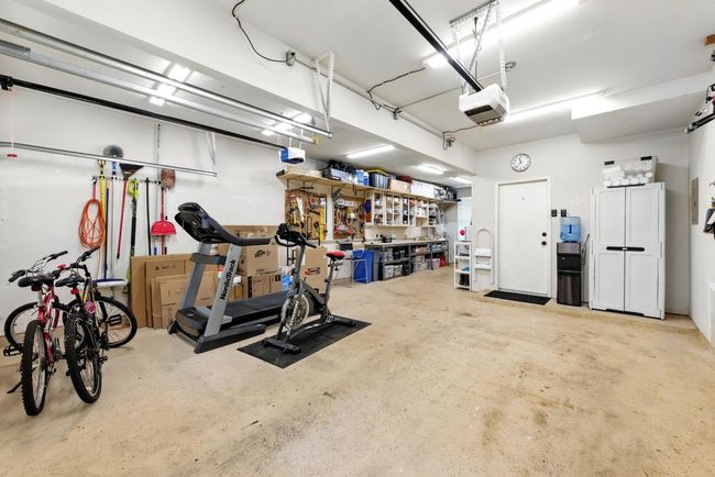 Garage with a garage door opener and a workshop area | Image 28