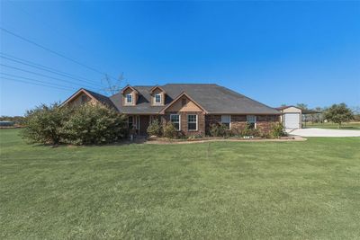 View of front of property featuring a front lawn and a garage | Image 1