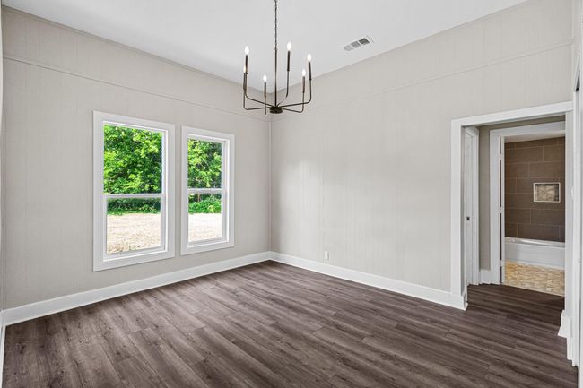 Unfurnished room with a chandelier and dark wood finished floors | Image 11