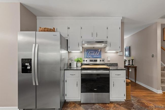 Kitchen with stainless steel appliances, exhaust hood, and white cabinetry | Image 14