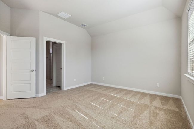 Unfurnished bedroom with carpet, vaulted ceiling, and baseboards | Image 14