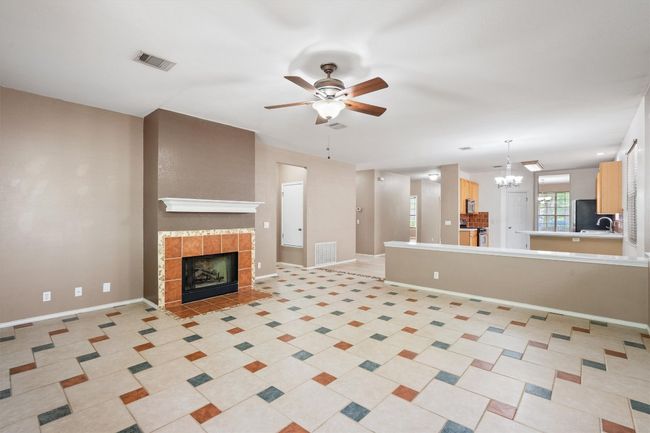 Living room with tile, ceiling fan, and fireplace | Image 11