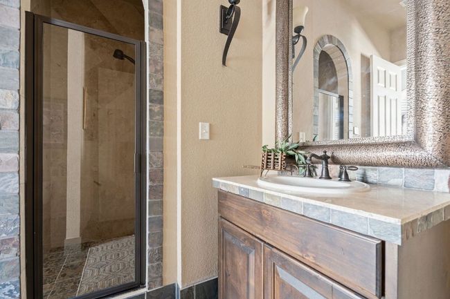 Full bathroom featuring a textured wall, vanity, and a walk-in shower | Image 34