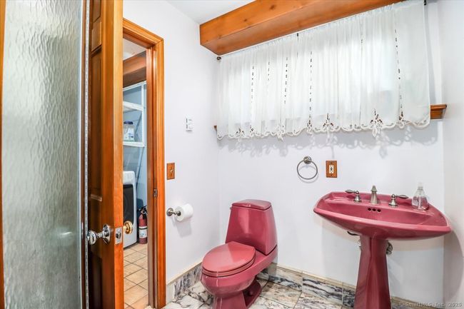 Find a full bathroom on the main level with a laundry room just outside the door. | Image 25