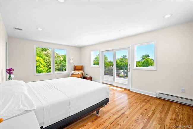 Bedroom featuring access to outside, light wood finished floors, recessed lighting, baseboards, and baseboard heating | Image 26