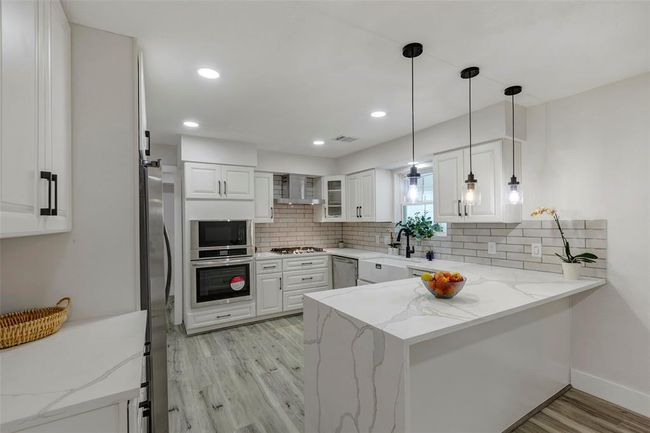 Chef's dream kitchen with new appliances, Quartz countertops, light fixtures and cabinets. | Image 16