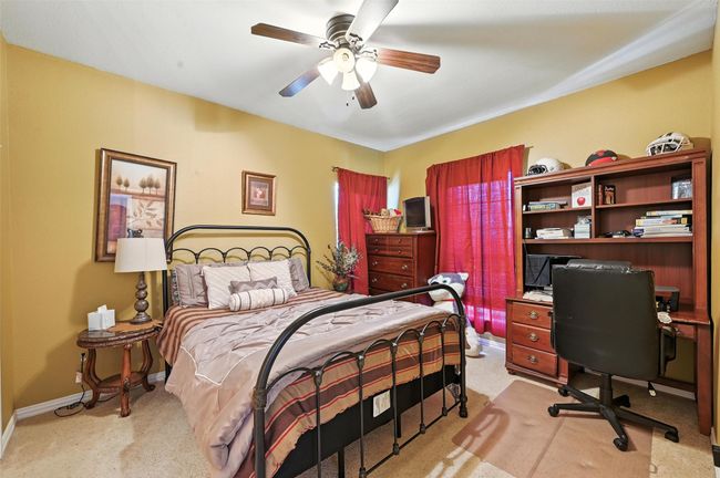 Bedroom with light colored carpet, a desk, and a ceiling fan | Image 21