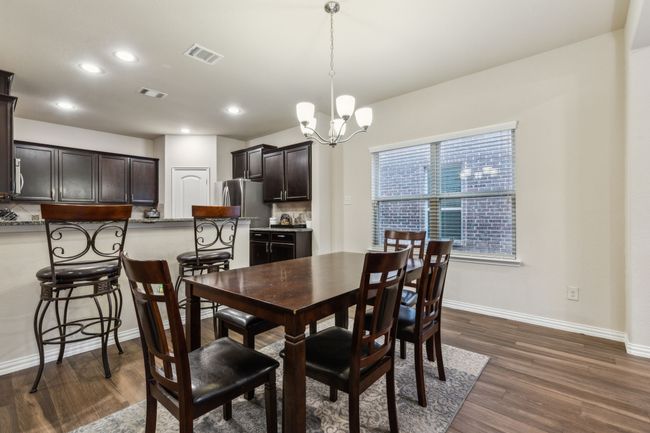 Dining room featuring dark wood-type flooring, a chandelier, baseboards, and recessed lighting | Image 10