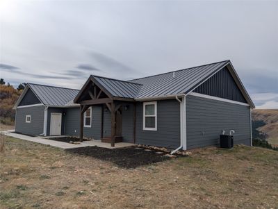 Back of property featuring a lawn and central AC unit | Image 1