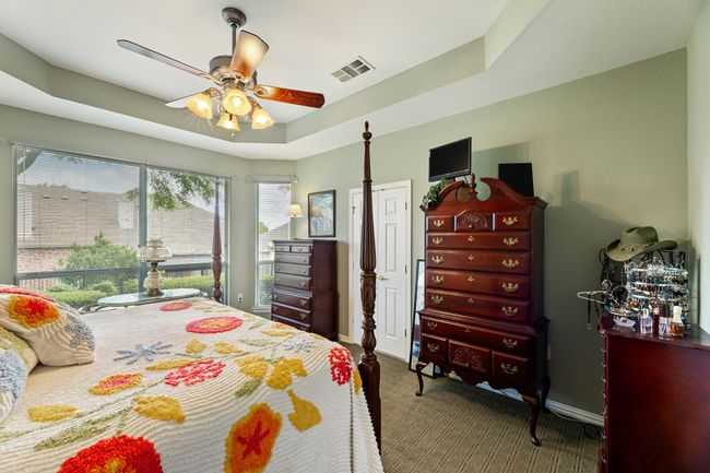 Carpeted bedroom with ceiling fan, a tray ceiling, and baseboards | Image 24