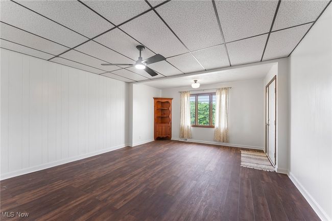 Unfurnished room with ceiling fan, dark wood-style floors, and a drop ceiling | Image 11