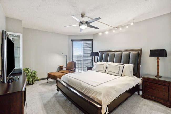 Primary bedroom is spacious with fresh carpet, modern fan and track lighting. | Image 23