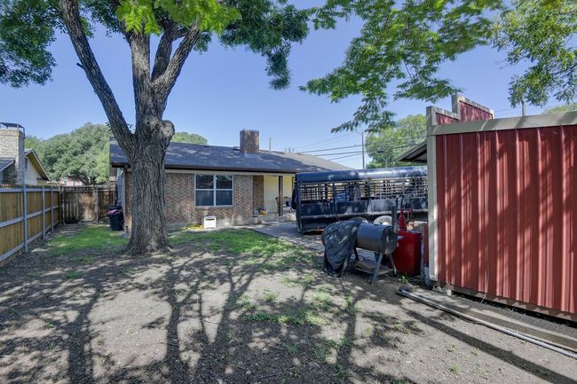 Rear view of property with a fenced backyard, brick siding, and a chimney | Image 24