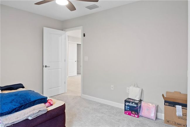 Bedroom featuring baseboards, visible vents, and light carpet | Image 27