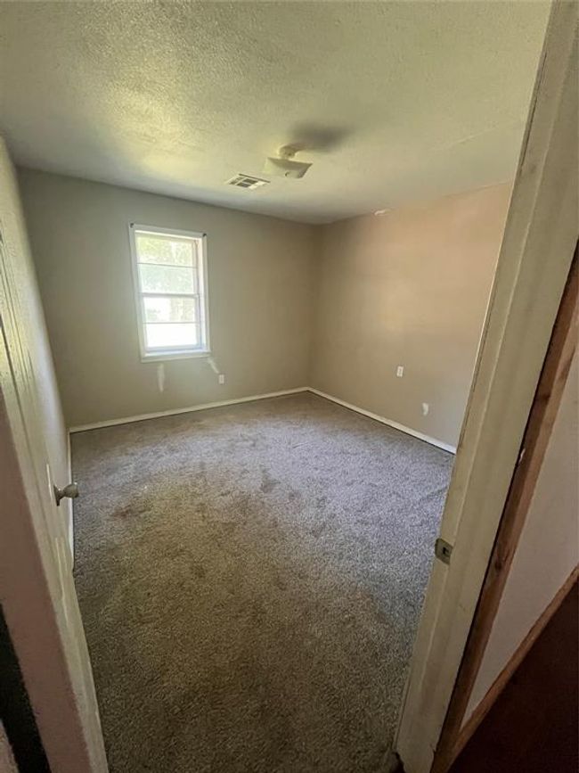 Carpeted spare room featuring a textured ceiling and baseboards | Image 17