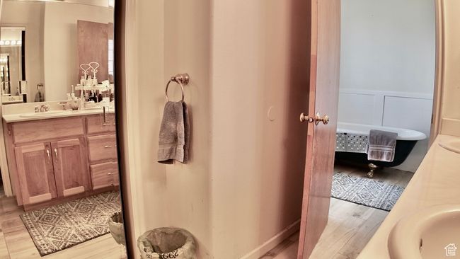 Bathroom with a wainscoted wall, vanity, and wood finished floors | Image 67
