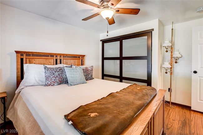 Bedroom with light wood-style flooring and ceiling fan | Image 15