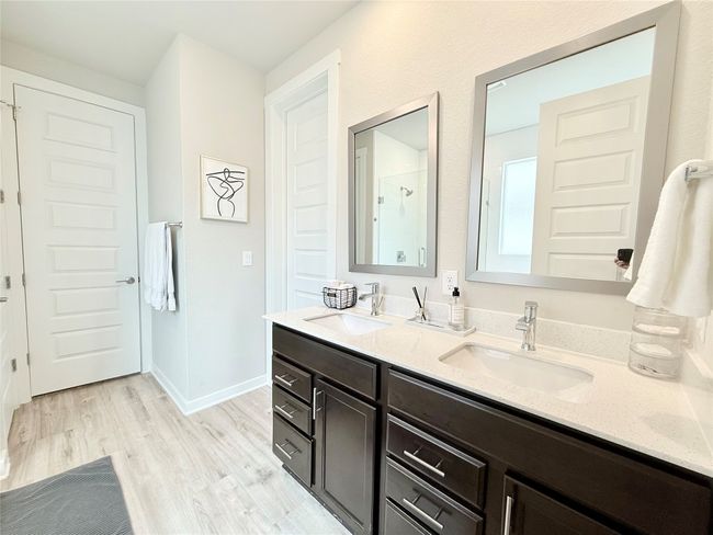 Bathroom featuring double vanity, a shower, wood finished floors, and a sink | Image 19