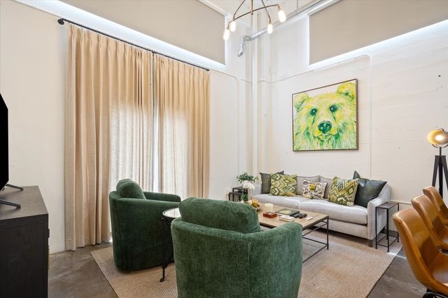 Living room featuring finished concrete floors and a towering ceiling | Image 6
