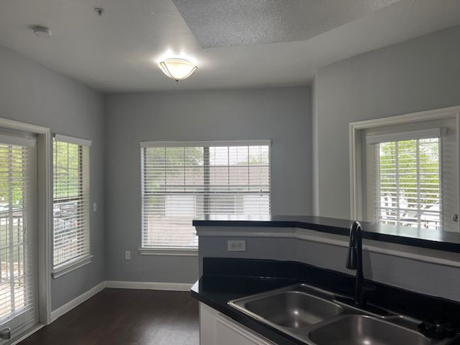 Kitchen featuring dark countertops, a sink, a wealth of natural light, and dark wood-style flooring | Image 12