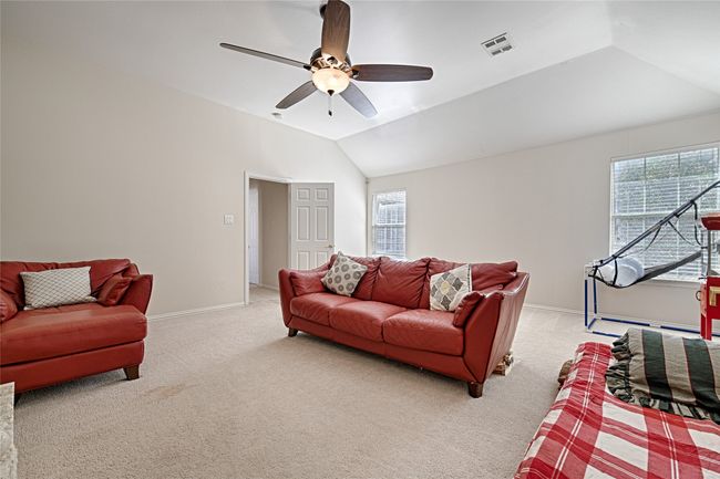 Living room with lofted ceiling, baseboards, visible vents, and light colored carpet | Image 13
