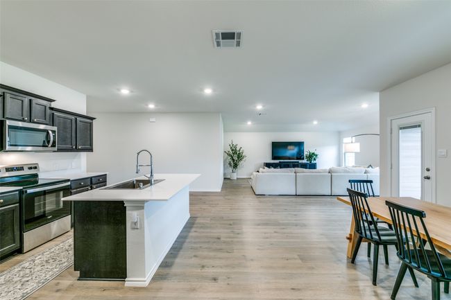 Kitchen featuring light hardwood / wood-style floors, stainless steel appliances, a center island with sink, and sink | Image 9