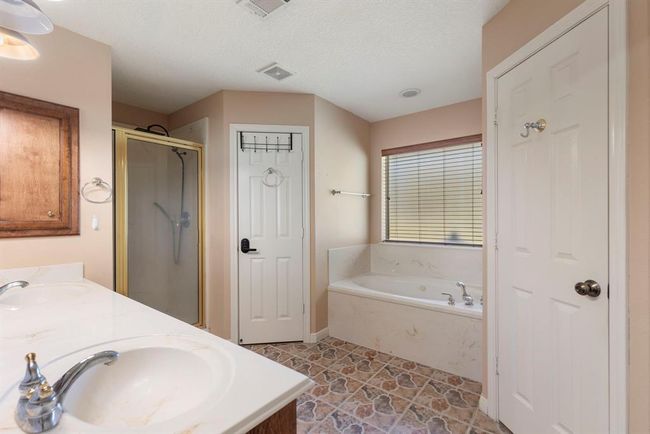Primary bath with jetted tub and walk-in shower. | Image 22