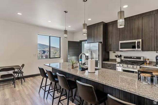 Kitchen featuring stainless steel appliances, a sink, a kitchen bar, and modern cabinets | Image 66