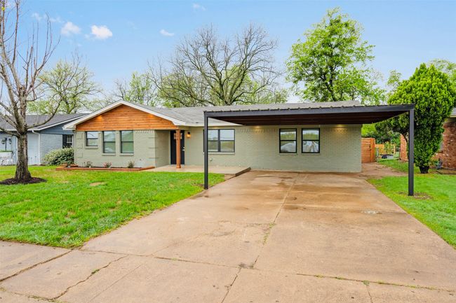 Mid-century modern home with brick siding, a front lawn, and driveway | Image 5