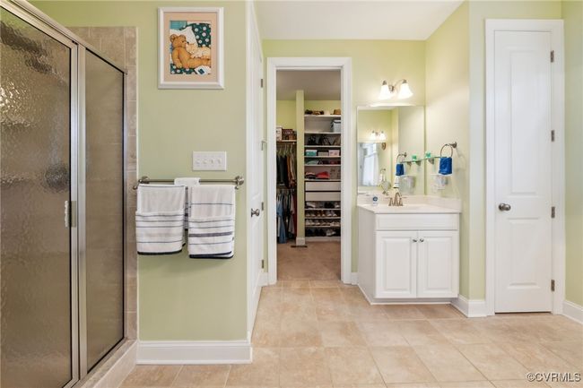 Looking into the walk-in closet with custom shelving installed after the home was built. Water closet through closed door on left and linen cabinet through closed door on right. | Image 20