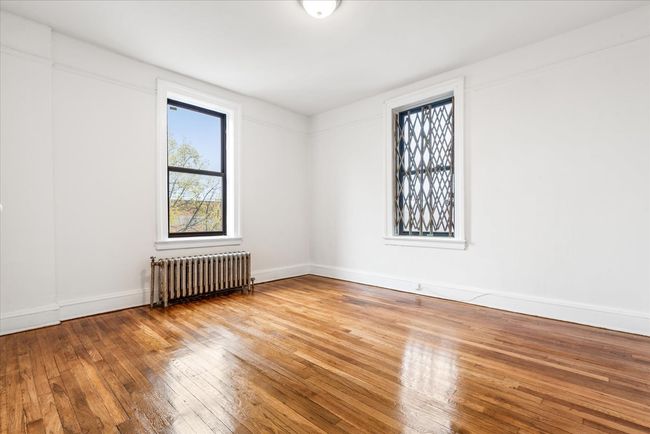 Spare room with radiator heating unit, hardwood / wood-style floors, and baseboards | Image 6