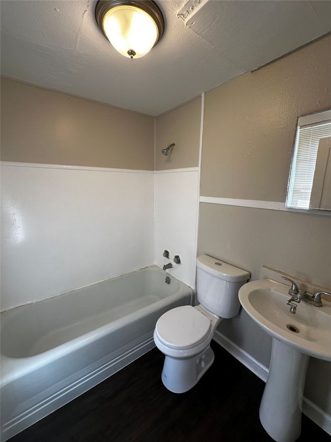 Bathroom with wood-type flooring, bathtub / shower combination, and toilet | Image 6