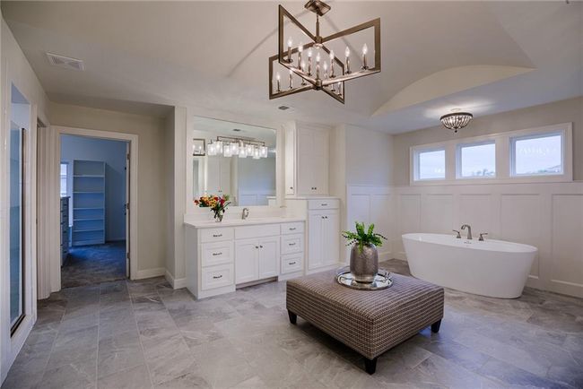 Bathroom with a bathtub, tile flooring, and vanity | Image 34