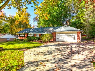 Ranch-style home with a front yard and a garage | Image 1