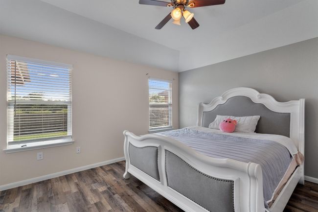 Bedroom featuring wood finished floors, baseboards, a ceiling fan, and vaulted ceiling | Image 14
