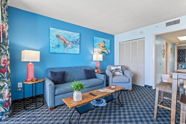 Carpeted living area featuring a textured ceiling | Image 17