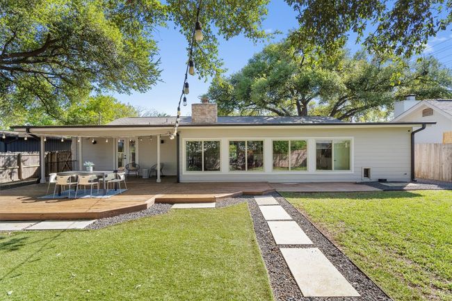 A large deck overlooks a generous mix of lawn and turf mingled with xeriscaping and pavers. | Image 6