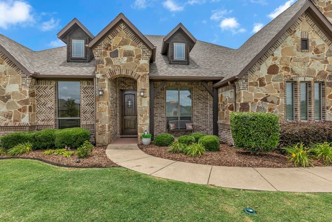 View of front of property with stone siding, a front lawn, a shingled roof, and brick siding | Image 6