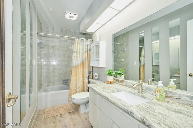 Bathroom featuring vanity, shower / bathtub combination with curtain, and wood finished floors | Image 29