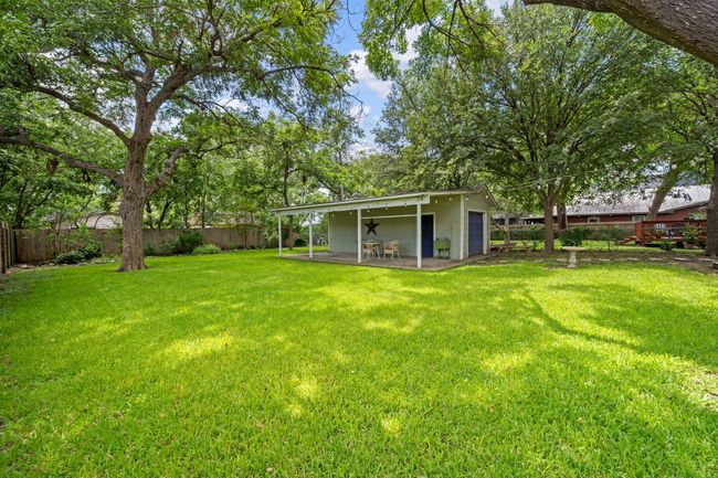 Fenced backyard with a patio | Image 11