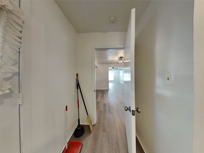 Corridor with wood finished floors, baseboards, and a textured ceiling | Image 18