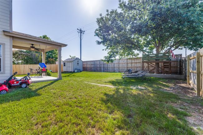View of yard with a patio area, a storage shed, a ceiling fan, and an outbuilding | Image 39