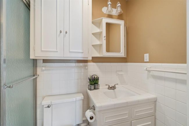 Bathroom with vanity, tile walls, wainscoting, and an enclosed shower | Image 32