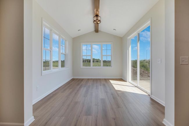 Morning room with vaulted ceiling and decorative beam combines well with all the natural light shining in. | Image 4