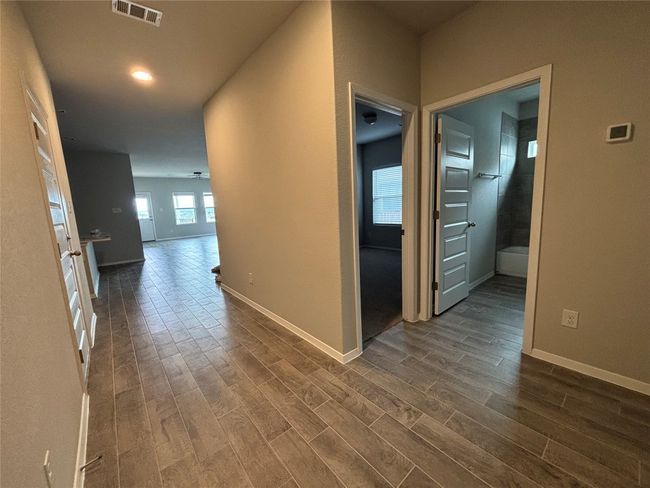 Hallway with dark wood-type flooring and baseboards | Image 9